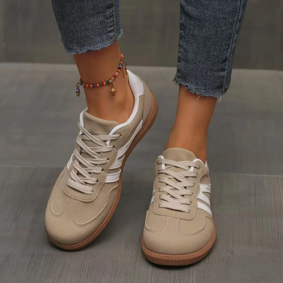 Women's beige and white retro trainers worn from the front
