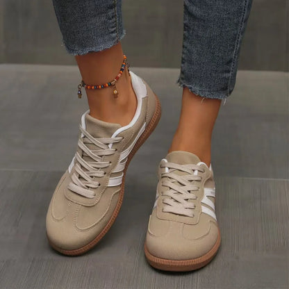 Women's beige and white retro trainers worn from the front