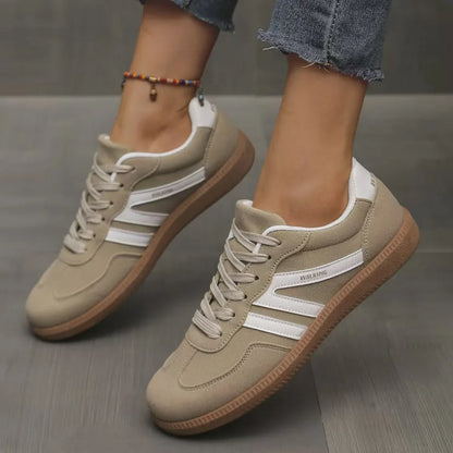 Women's beige and white retro trainers worn from the side