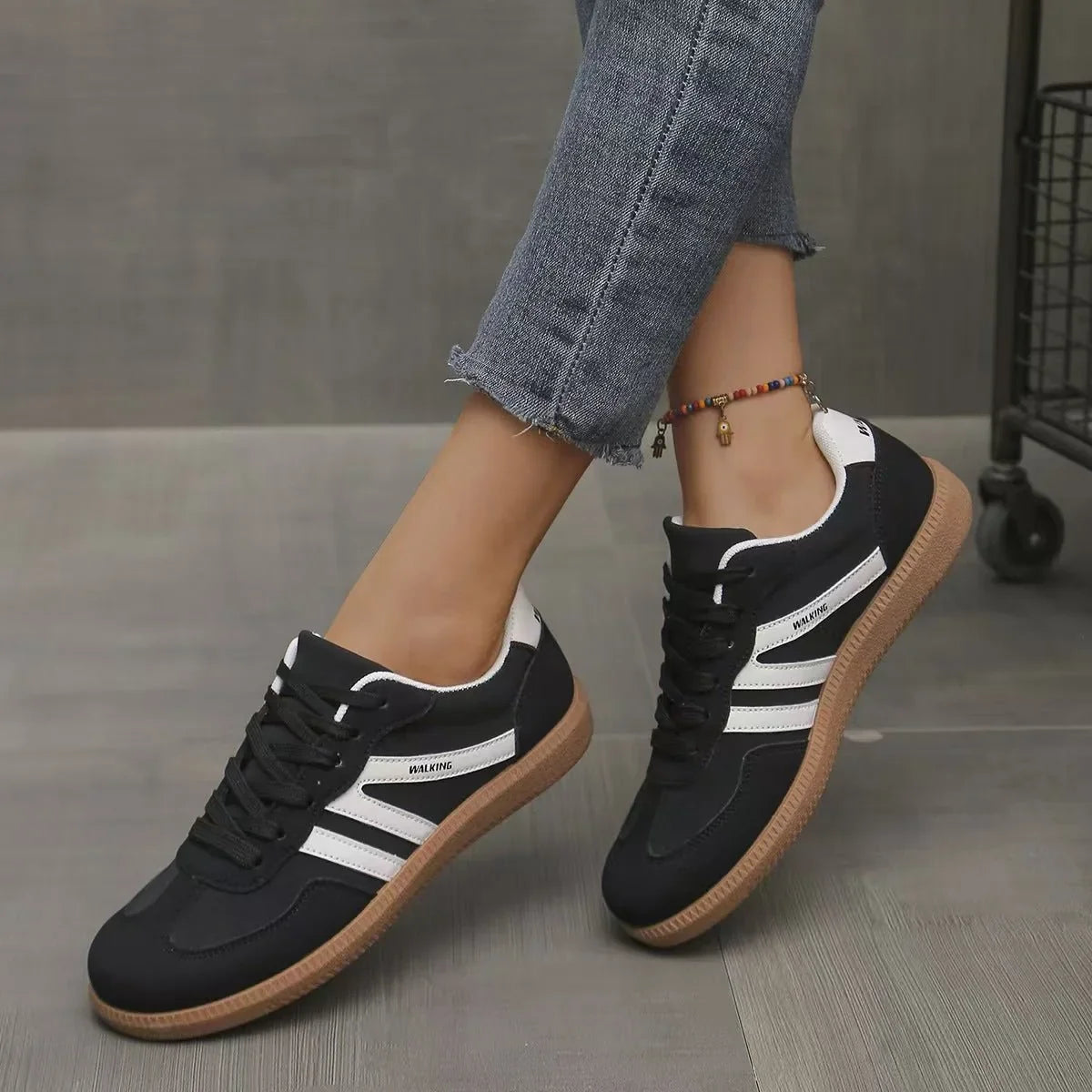 Women's black and white retro trainers worn in a front three quarter view