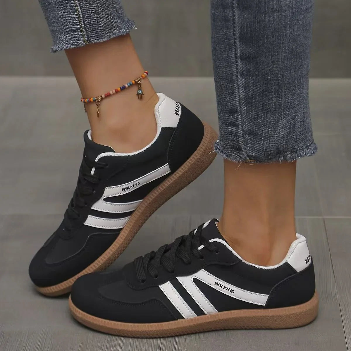 Women's black and white retro trainers worn from the side