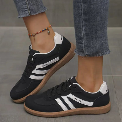 Women's black and white retro trainers worn from the side