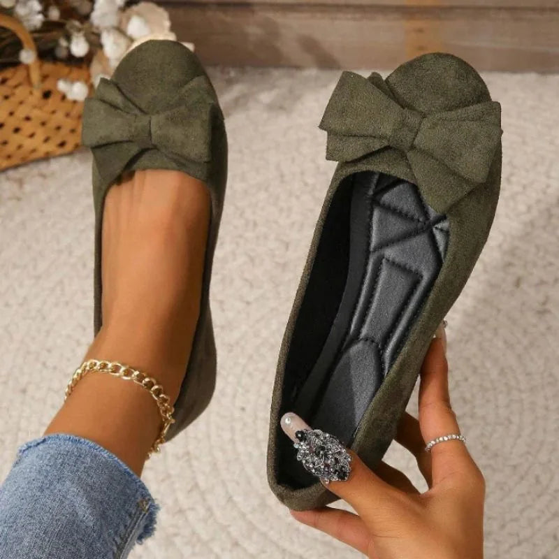 Dark green ballet flat shown on foot with the cushioned footbed visible