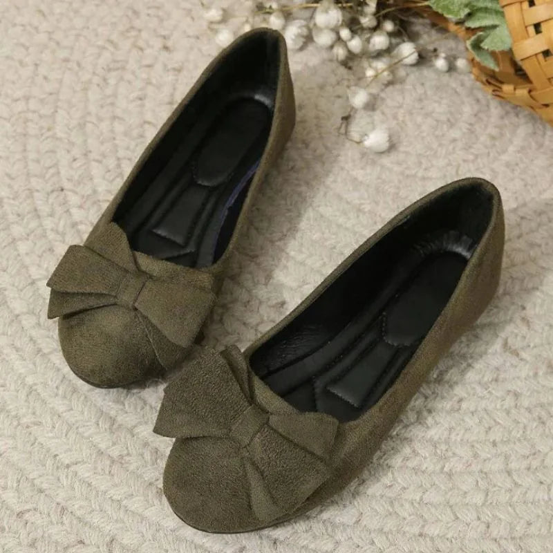 Pair of dark green bow ballet flats, top view