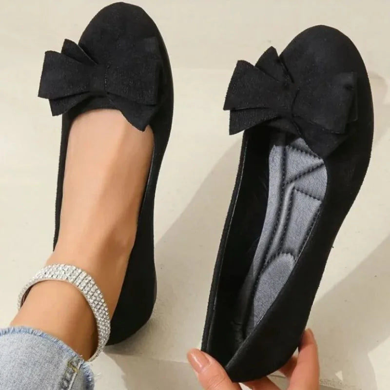 Black ballet flat shown on foot with the cushioned footbed visible