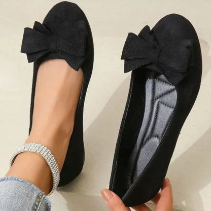 Black ballet flat shown on foot with the cushioned footbed visible