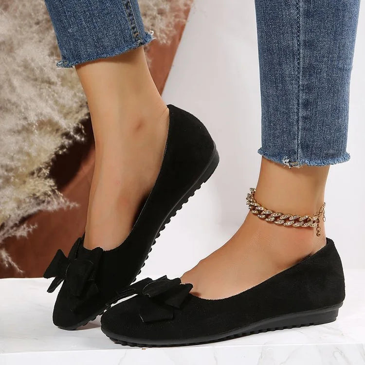 Black bow ballet flats worn with jeans, side view