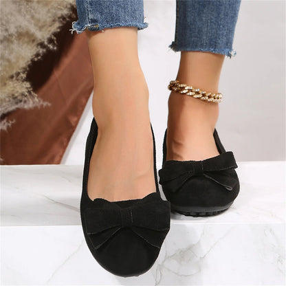 Black bow ballet flats worn with jeans, front view
