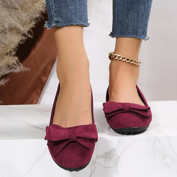 Red bow ballet flats worn with jeans, front view