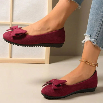 Red bow ballet flats worn with jeans, side view
