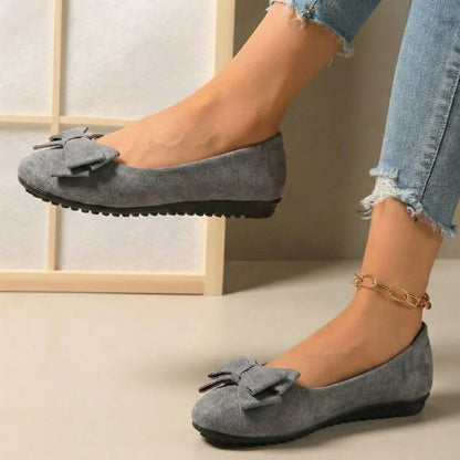Grey bow ballet flats worn with jeans, side view