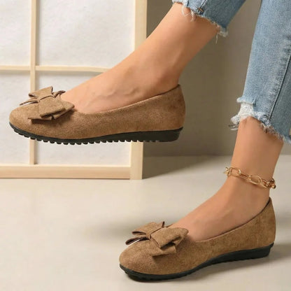 Light brown bow ballet flats worn with jeans, side view