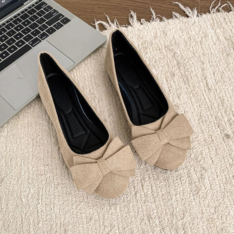 Pair of beige bow ballet flats, top view