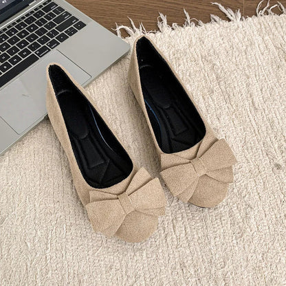 Pair of beige bow ballet flats, top view