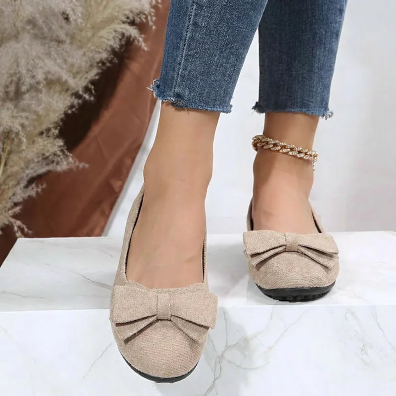 Beige bow ballet flats worn with jeans, front view