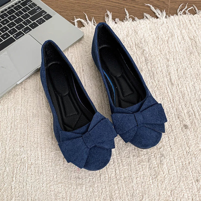 Pair of navy blue bow ballet flats, top view