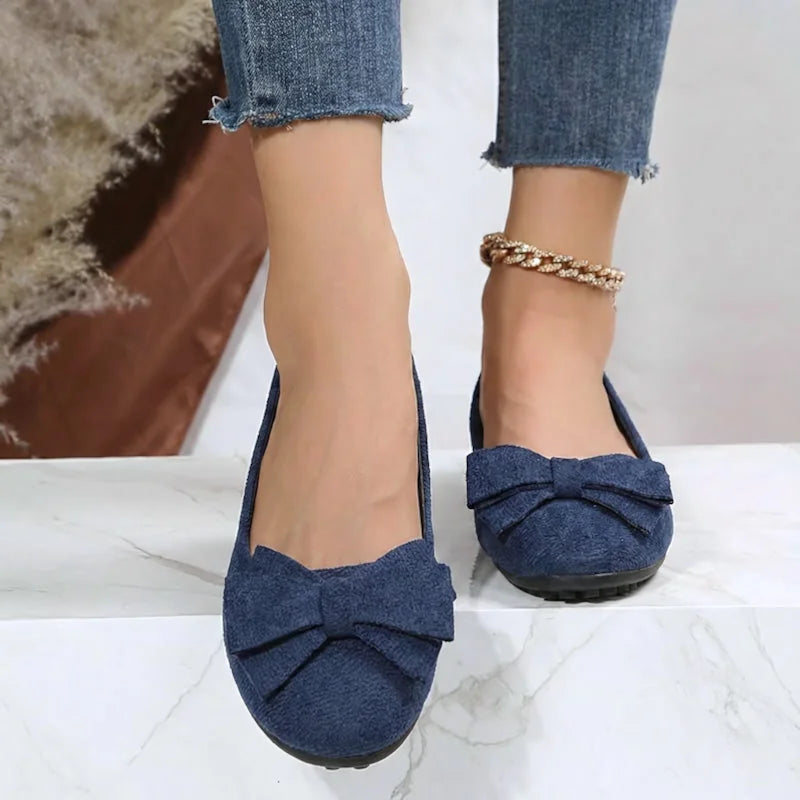 Navy blue bow ballet flats worn with jeans, front view