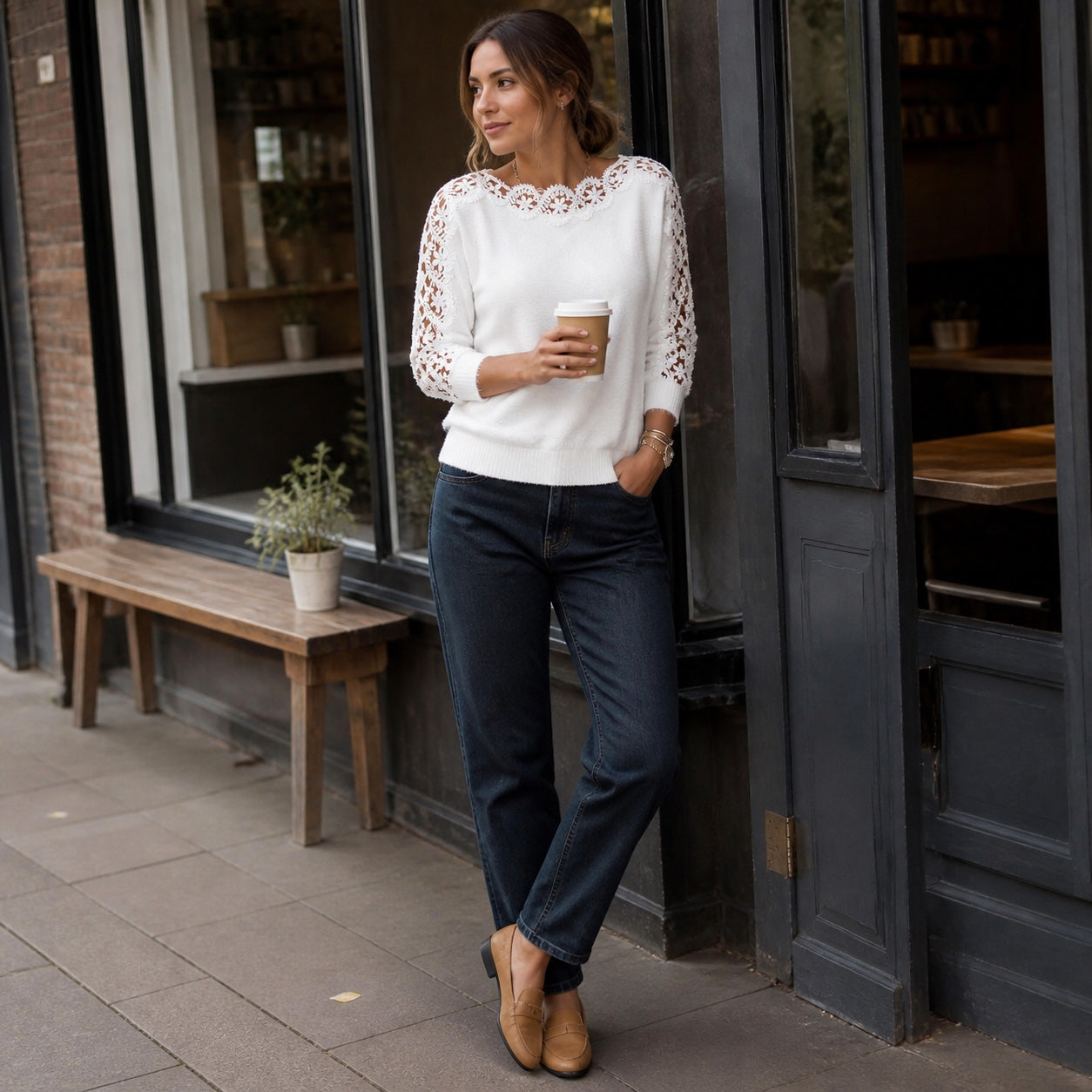 Woman styling the Pearl White lace-panel knit top outside a British café